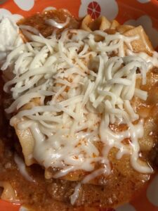 A bowl of Lasagna Soup topped with shredded mozzarella cheese.